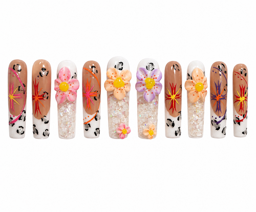 Long square press-ons layer warm brown and nude tones with leopard print accents, colorful starburst nail art in orange, pink, and purple, raised 3D flowers in pink, peach, and lavender, iridescent crystal flake fills, and swirling orange and purple details.