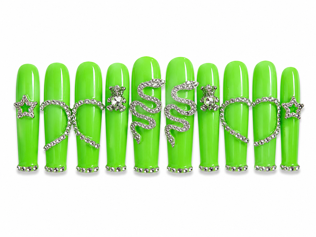 Handmade long coffin press-on nails in glossy neon green featuring silver rhinestone snake charms, heart outlines, teddy bear accents, and star details for a bold luxury statement nail design on a white background.