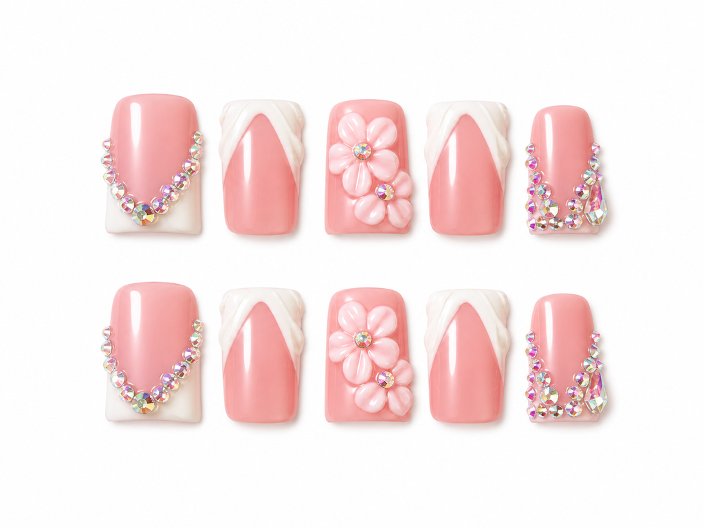 Set of pink press on nails with floral designs and decorative elements on a white background.