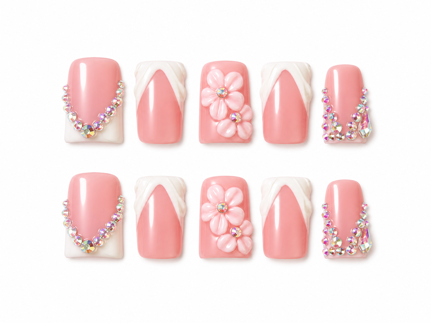 Set of pink press on nails with floral designs and decorative elements on a white background.