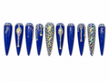 extra-long stiletto press-ons, royal blue — a rich, almost cobalt shade — covered in iridescent AB rhinestones arranged in arcs, trails, and dense clusters, with large diamond- cut gemstone centerpieces and scattered gold glitter on alternate nails. 