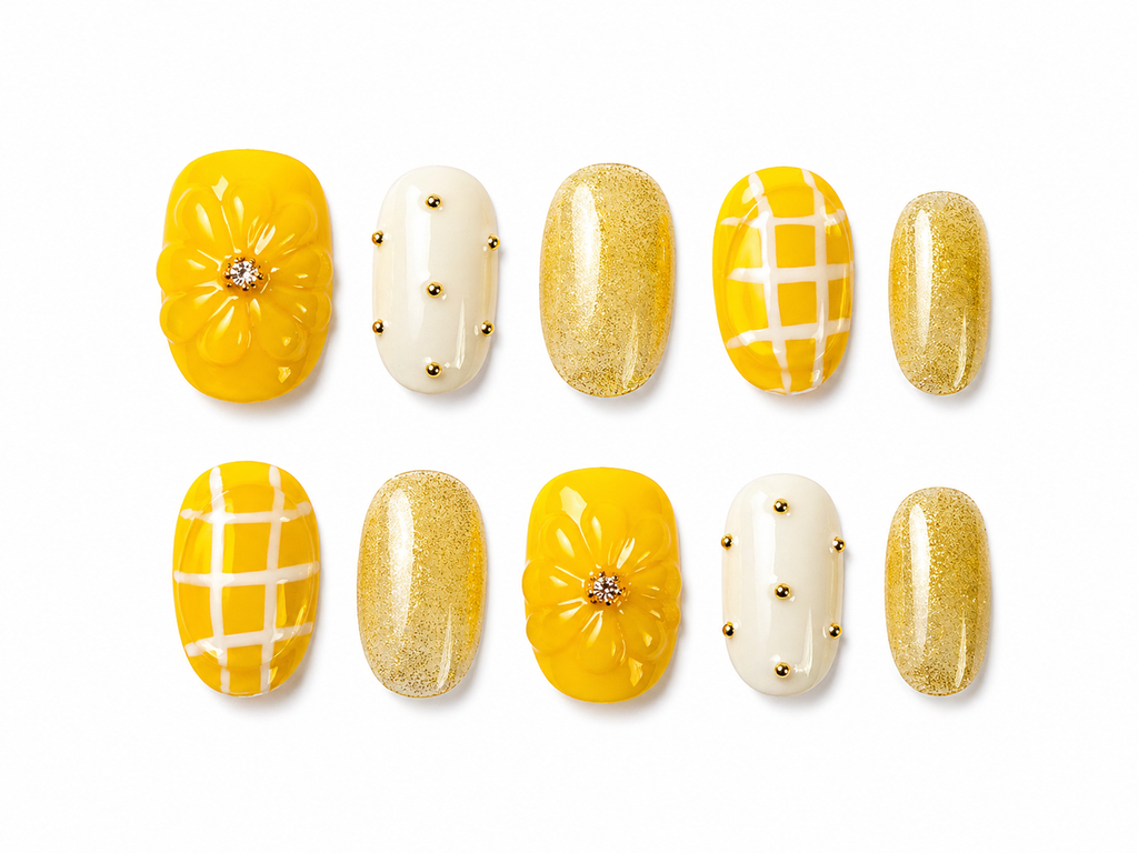 yellow, gold glitter, creamy white press on nails with a bold 3D sculpted flower centerpiece.